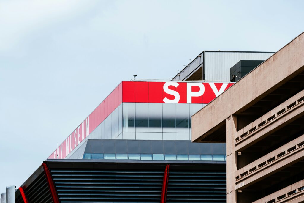 In daytime, the corner of the top of Spy museum against a blue sky. 